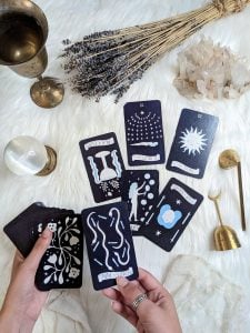 Goddess provisions tarot cards with background of dried lavender crystals candle dampner bell chalice and orb