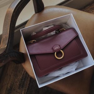 brown jw peil handbag with metal detail in box on chair