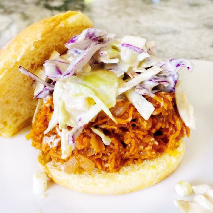 vegan pulled pork sandwich topped with coleslaw