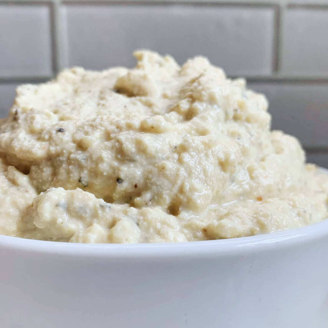 quick vegan ricotta in white bowl and white tile backsplash