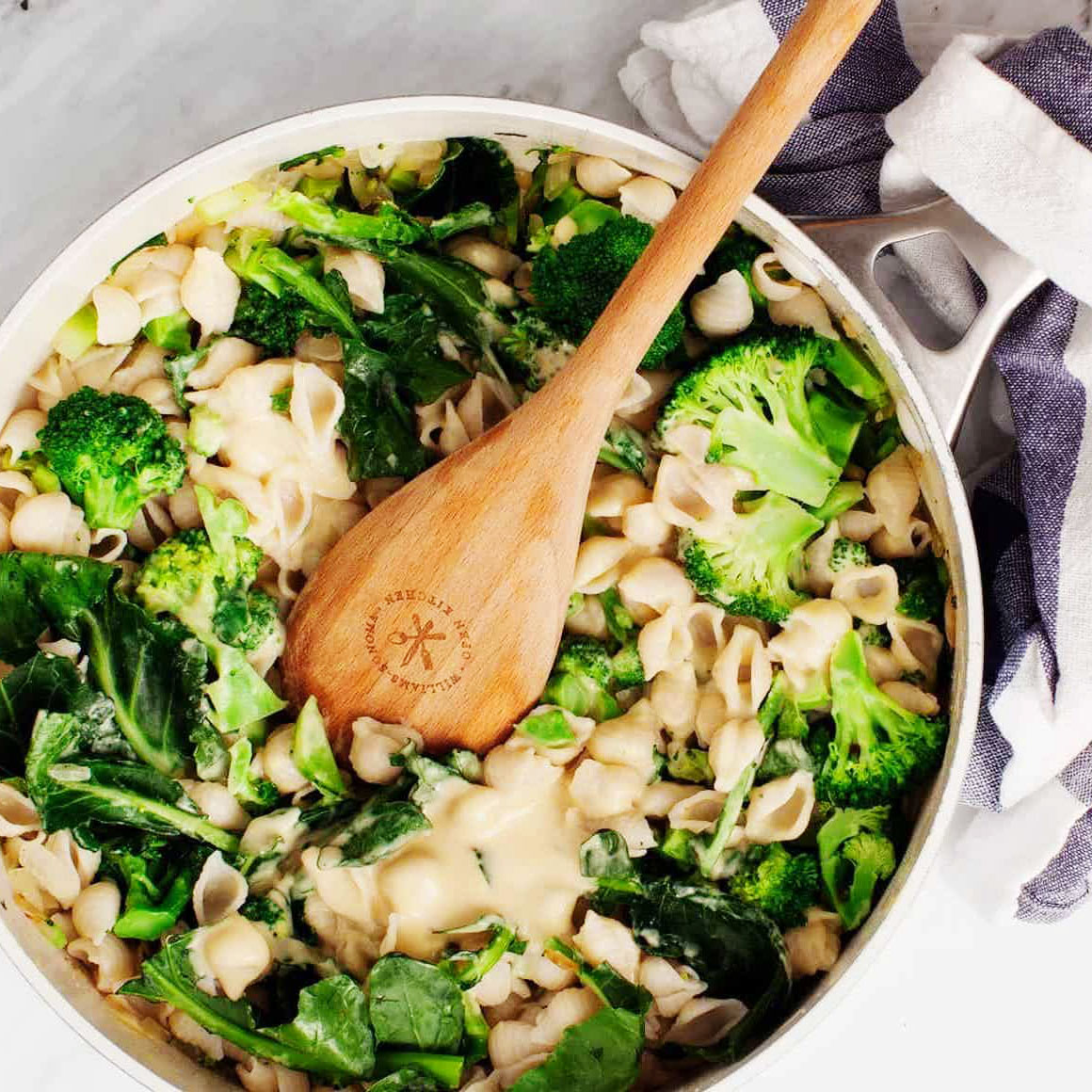 creamy vegan pasta mini shells with greens and broccoli wooden salad spoon