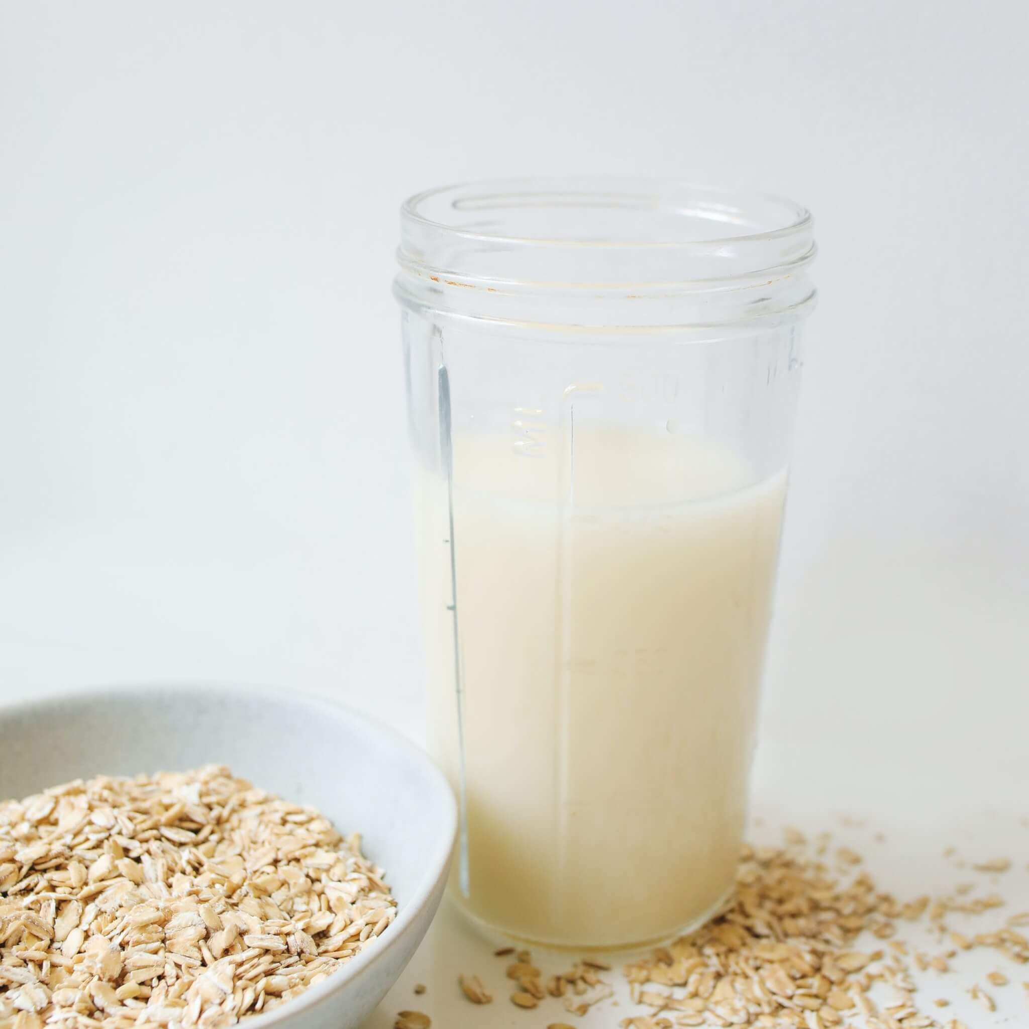 bowl of oats and oat milk in measuring cup