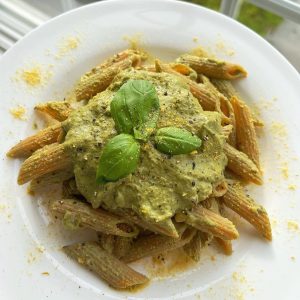 soco tahini and pesto as sauce on pasta bowl garnished basil
