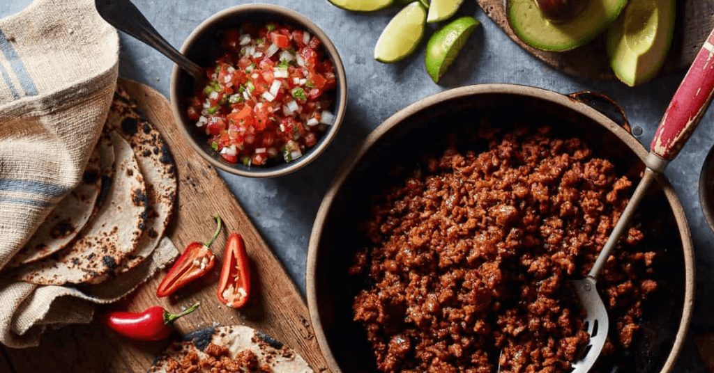 vegan chorizo in skillet with bowl of salsa