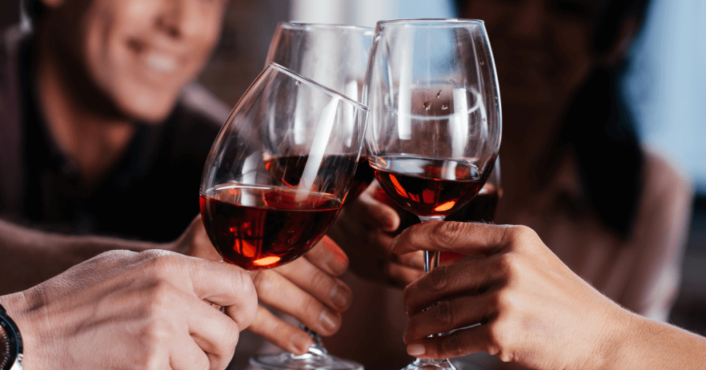 three hands cheering with wine