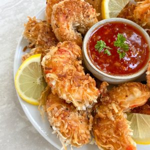 the plant based seafood co coconut shrimp with lemon slices and red sauce
