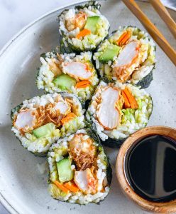 plate of six sushi rolls of Plant Based Seafood Co. with vegetables soy sauce and chopsticks