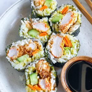 plate of six sushi rolls of Plant Based Seafood Co. with vegetables soy sauce and chopsticks