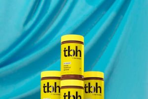 4 stacked jars of tbh hazelnut spread on light blue background