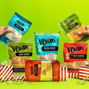 Assorted Packaged Vevan Shredded Cheeses on Green Background