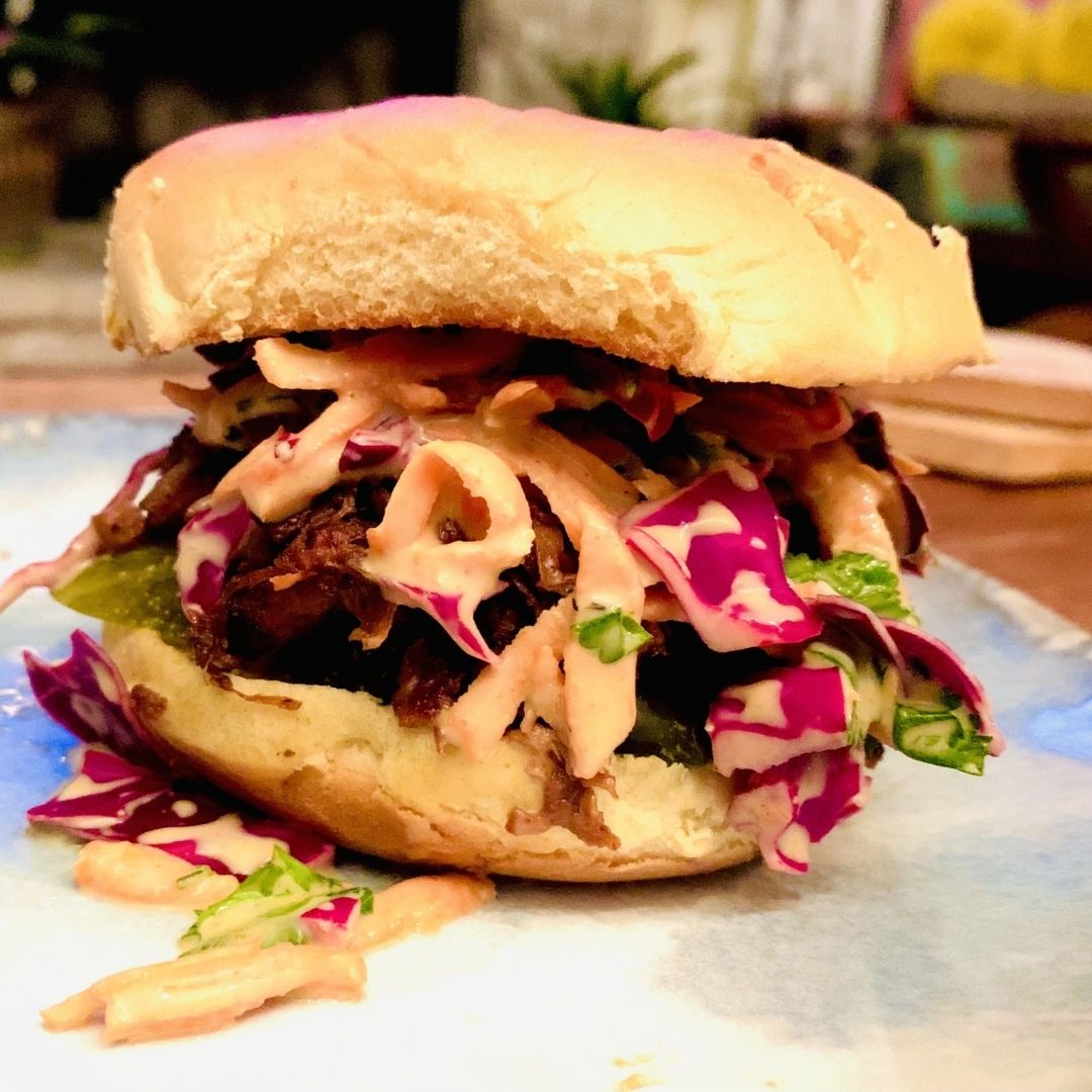 closeup of super bowl pulled jackfruit sliders with coleslaw and creamy sauce