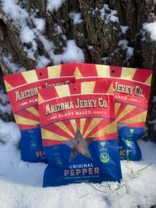 Three Packages of Hot Pepper Arizona Jerky Co. with snow background