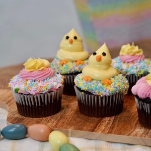 Easter Glamaris Cupcakes decorated with sprinkles and yellow and pink frosting