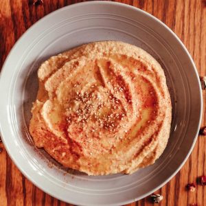 hummus dip in a bowl topped with sesame seeds