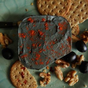 vegan cheese with paprika nuts olives and crackers