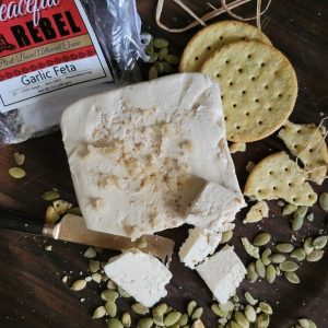Peaceful Rebel Garlic Feta Vegan Cheese with pumpkin seeds and crackers