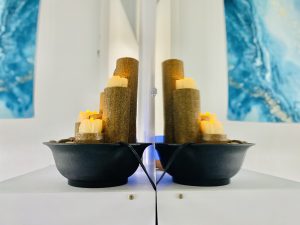 water fountain decoration on a shelf next to a mirror