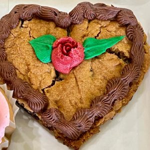 Heart shaped cookie cake with rose and chocolate frosting