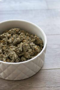 Containers of Dylan's Dog Food quinoa and chickpeas in a bowl on wooden background