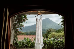Wedding dress hanging in a doorway with mountain in the background