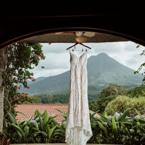 Wedding dress hanging in a doorway with mountain in the background